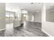 Open floor plan showcasing the kitchen, dining, and living areas with gray wood flooring at 11780 Se 178Th St, Summerfield, FL 34491