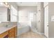 Bathroom featuring a soaking tub and a walk-in shower with a glass door at 11780 Se 178Th St, Summerfield, FL 34491