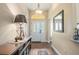 Bright entryway features a decorative chandelier, stylish console table, and wood-look floors at 1222 Camero Dr, The Villages, FL 32159