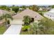 Charming home boasts lush landscaping, a well-manicured lawn, and an attached two-car garage at 1222 Camero Dr, The Villages, FL 32159