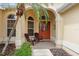 Inviting covered porch with seating offers a relaxing outdoor space, adjacent to arched windows at 1222 Camero Dr, The Villages, FL 32159