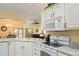 Bright kitchen features white cabinets, granite countertops, and modern appliances, perfect for cooking and entertaining at 1222 Camero Dr, The Villages, FL 32159