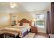 Relaxing main bedroom featuring a decorative headboard, hardwood floors, and bright windows at 1222 Camero Dr, The Villages, FL 32159