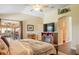 Spacious main bedroom with a cozy fireplace, entertainment center, and access to the outdoor patio at 1222 Camero Dr, The Villages, FL 32159