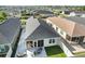 Aerial view showcasing backyard with a screened-in patio and cozy seating area in a well-maintained community at 1251 Saranac Pl, The Villages, FL 32163