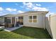 Lovely backyard featuring a concrete patio, green grass, and a tall white fence at 1251 Saranac Pl, The Villages, FL 32163