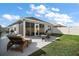 Private backyard with a screened-in lanai, patio furniture, and well-maintained lawn at 1251 Saranac Pl, The Villages, FL 32163