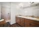Elegant bathroom featuring a double sink vanity, granite countertops, and a tiled shower at 1251 Saranac Pl, The Villages, FL 32163