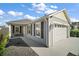 Charming single-story home featuring a two-car garage and well-maintained landscaping under a partly cloudy sky at 1251 Saranac Pl, The Villages, FL 32163