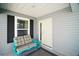 Inviting front porch with seating, dark shutters, and stylish decor at 1251 Saranac Pl, The Villages, FL 32163