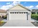 Attached two-car garage with white door and trim complementing the grey siding at 1251 Saranac Pl, The Villages, FL 32163