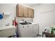 Convenient laundry area features an utility sink, storage, and modern washer and dryer at 1251 Saranac Pl, The Villages, FL 32163