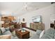Open-concept living room with modern furnishings, wood floors, and access to the kitchen and dining area at 1251 Saranac Pl, The Villages, FL 32163
