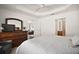 Bright main bedroom with tray ceilings, neutral walls, and entry to the Primary bath and living space at 1251 Saranac Pl, The Villages, FL 32163