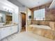 Bright bathroom with double sink vanity, soaking tub, and tiled shower at 13519 Bristlecone Cir, Orlando, FL 32828