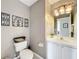 Powder room with a vanity featuring white cabinets and a round mirror at 13519 Bristlecone Cir, Orlando, FL 32828
