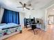 Bedroom with a ceiling fan, bed, desk with multiple computer monitors, and hardwood flooring at 13519 Bristlecone Cir, Orlando, FL 32828