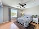 Bedroom features a neutral color palette, ceiling fan, a large window, and hardwood floors at 13519 Bristlecone Cir, Orlando, FL 32828