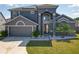Beautiful two-story home with a well-manicured lawn, gray stucco, and a two-car garage at 13519 Bristlecone Cir, Orlando, FL 32828