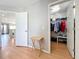 Hallway leading to living room and a walk-in closet; features light wood flooring at 13519 Bristlecone Cir, Orlando, FL 32828