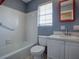 Bathroom with white tile, vanity and a window at 1400 Eudora Rd # A08, Mount Dora, FL 32757