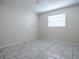 Bedroom with neutral walls, gray tile and a window at 1400 Eudora Rd # A08, Mount Dora, FL 32757