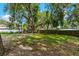 Spacious backyard with mature trees and partial fence at 1406 Spartan Ave, Leesburg, FL 34748