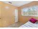 Small bedroom with a window, door, and a single bed at 1406 Spartan Ave, Leesburg, FL 34748