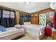 Shared bedroom with two twin beds and wood paneling at 1406 Spartan Ave, Leesburg, FL 34748