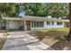 Front exterior showcasing the home's facade, featuring a carport, well-kept lawn, and inviting entrance at 1406 Spartan Ave, Leesburg, FL 34748