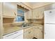 Cozy kitchen features retro cabinets, stainless steel sink and white dishwasher at 1406 Spartan Ave, Leesburg, FL 34748