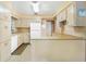 Functional kitchen featuring classic cabinets, white appliances, and a cozy breakfast bar at 1406 Spartan Ave, Leesburg, FL 34748