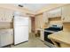 Functional kitchen featuring classic cabinets and white appliances at 1406 Spartan Ave, Leesburg, FL 34748