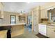 Cozy kitchen features retro cabinets, breakfast bar, and sliding glass doors to the lanai at 1406 Spartan Ave, Leesburg, FL 34748