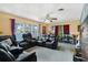 Comfortable living room with black leather recliners, ceiling fan and large picture window at 1406 Spartan Ave, Leesburg, FL 34748