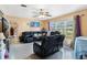 Bright living room boasts ample seating, a ceiling fan, and a large window at 1406 Spartan Ave, Leesburg, FL 34748