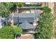 An aerial view showcases the home's dark roof, screened-in pool, and lush landscaping, highlighting its features at 14305 Pine Cone Trl, Clermont, FL 34711