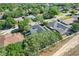 An aerial view displays the home with its screened pool, backyard, and surrounding mature trees at 14305 Pine Cone Trl, Clermont, FL 34711