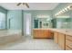 Bright bathroom featuring double sink vanity, garden tub and glass door to patio at 14305 Pine Cone Trl, Clermont, FL 34711