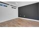 A minimalist room features wood flooring and a dark accent wall, creating a simple, stylish interior at 14305 Pine Cone Trl, Clermont, FL 34711