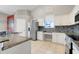 Bright kitchen with white cabinets, stainless steel refrigerator, granite countertops and mosaic backsplash at 14305 Pine Cone Trl, Clermont, FL 34711
