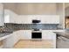 Well-equipped kitchen with stainless steel oven, microwave, white cabinets and granite countertops at 14305 Pine Cone Trl, Clermont, FL 34711