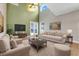 Staged living room features neutral furniture, a decorative rug, and large windows providing natural light at 14305 Pine Cone Trl, Clermont, FL 34711