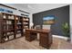 A well-lit office features a wooden desk, bookcase, and tasteful decor, ideal for a productive workspace at 14305 Pine Cone Trl, Clermont, FL 34711