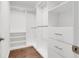 Well-organized walk-in closet with wooden floor, and built in shelving and drawers at 14305 Pine Cone Trl, Clermont, FL 34711
