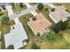 Aerial view of the property featuring manicured lawn, mature trees, and a screened-in porch at 1526 Blueberry Way, The Villages, FL 32162