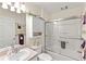 Bright bathroom with tiled shower, updated vanity, and convenient overhead storage at 1526 Blueberry Way, The Villages, FL 32162