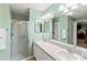 Bathroom featuring double sinks, a large mirror, and a walk-in shower with glass door at 1526 Blueberry Way, The Villages, FL 32162