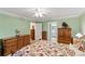 Bedroom with wooden furniture and floral bedspread, and door leading to the bathroom at 1526 Blueberry Way, The Villages, FL 32162