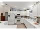 Bright kitchen featuring white cabinetry, modern appliances, and a view into the adjacent breakfast nook at 1526 Blueberry Way, The Villages, FL 32162